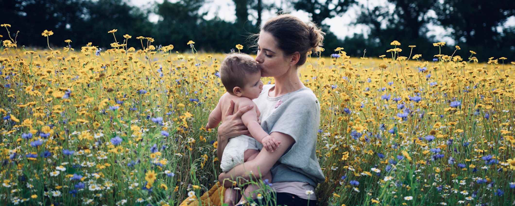 Promotional imagery for Mama Bamboo, featuring a mother and baby in a field of flowers.