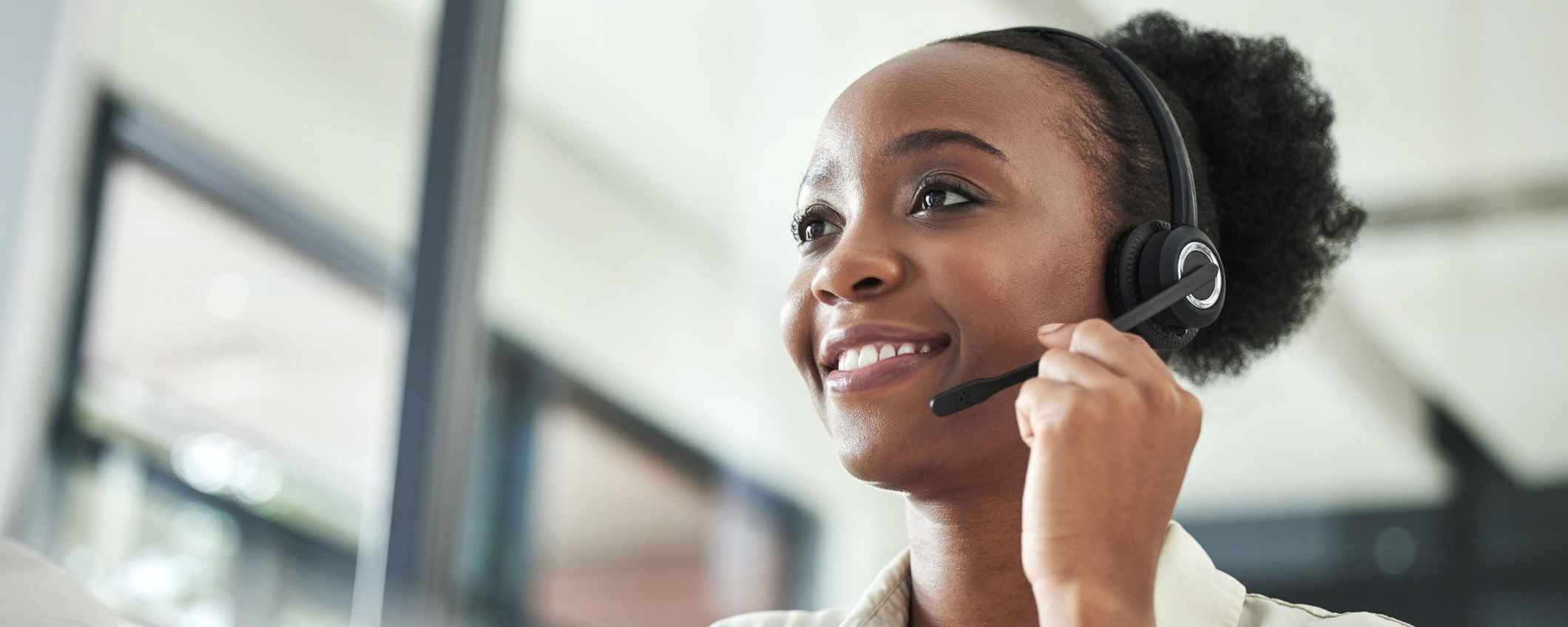 Black woman, call centre on phone with headset.