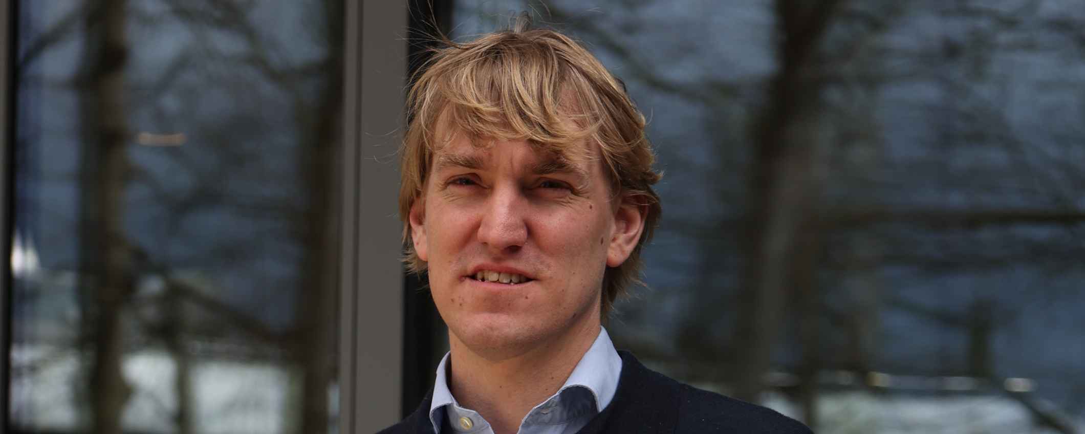 Sjoerd Rozing stood outside, windows behind him showing reflections of trees