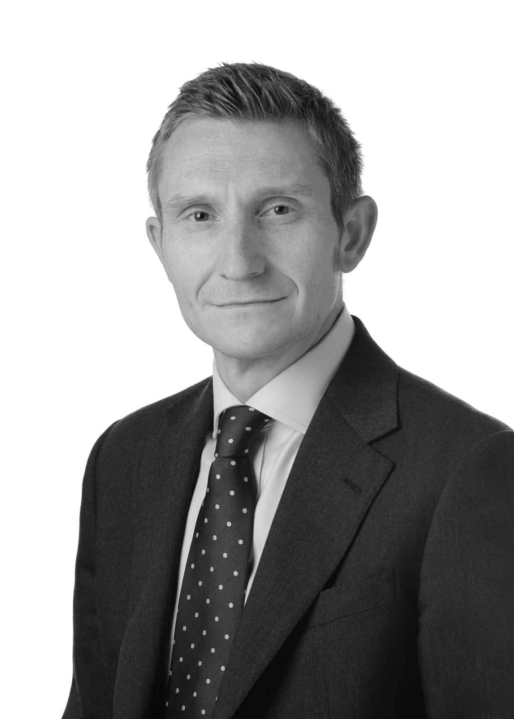 Black and white headshot of Adam Robbins in suit and tie