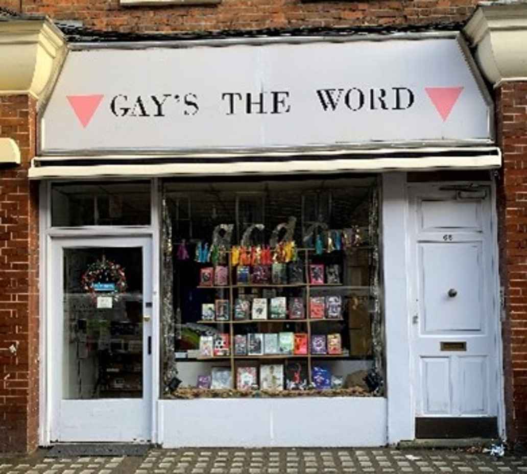 White bookshop with sign saying 'Gay's the word' set between two pink upturned triangles